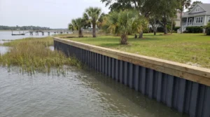 Newly installed vinyl sheet pile bulkhead with timber cap along a residential Lowcountry shoreline